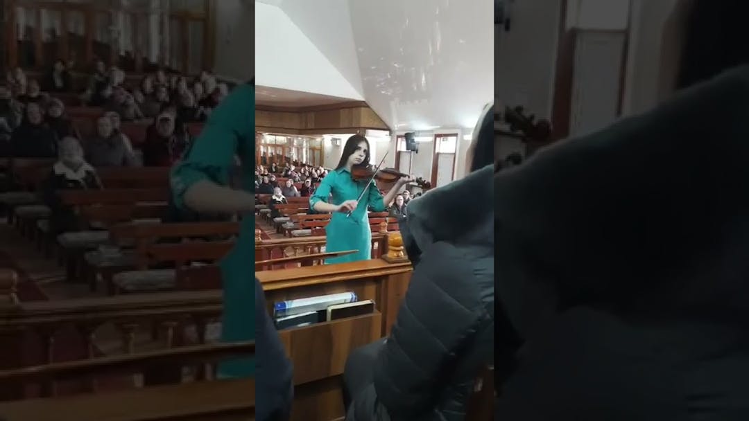 Videon Elena johtaa Vulcăneștin seurakunnan kuoroa viulun kanssa kansikuva
